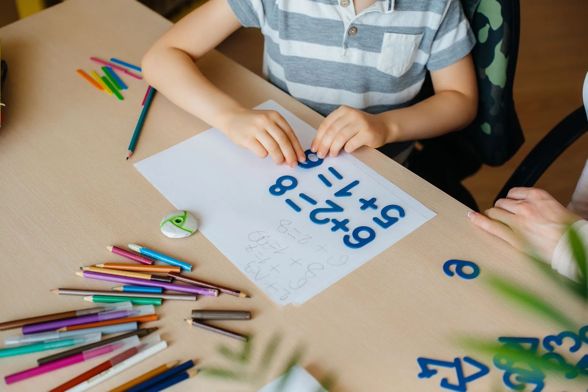 Enfant faisant des mathématiques avec des chiffres prédécoupés