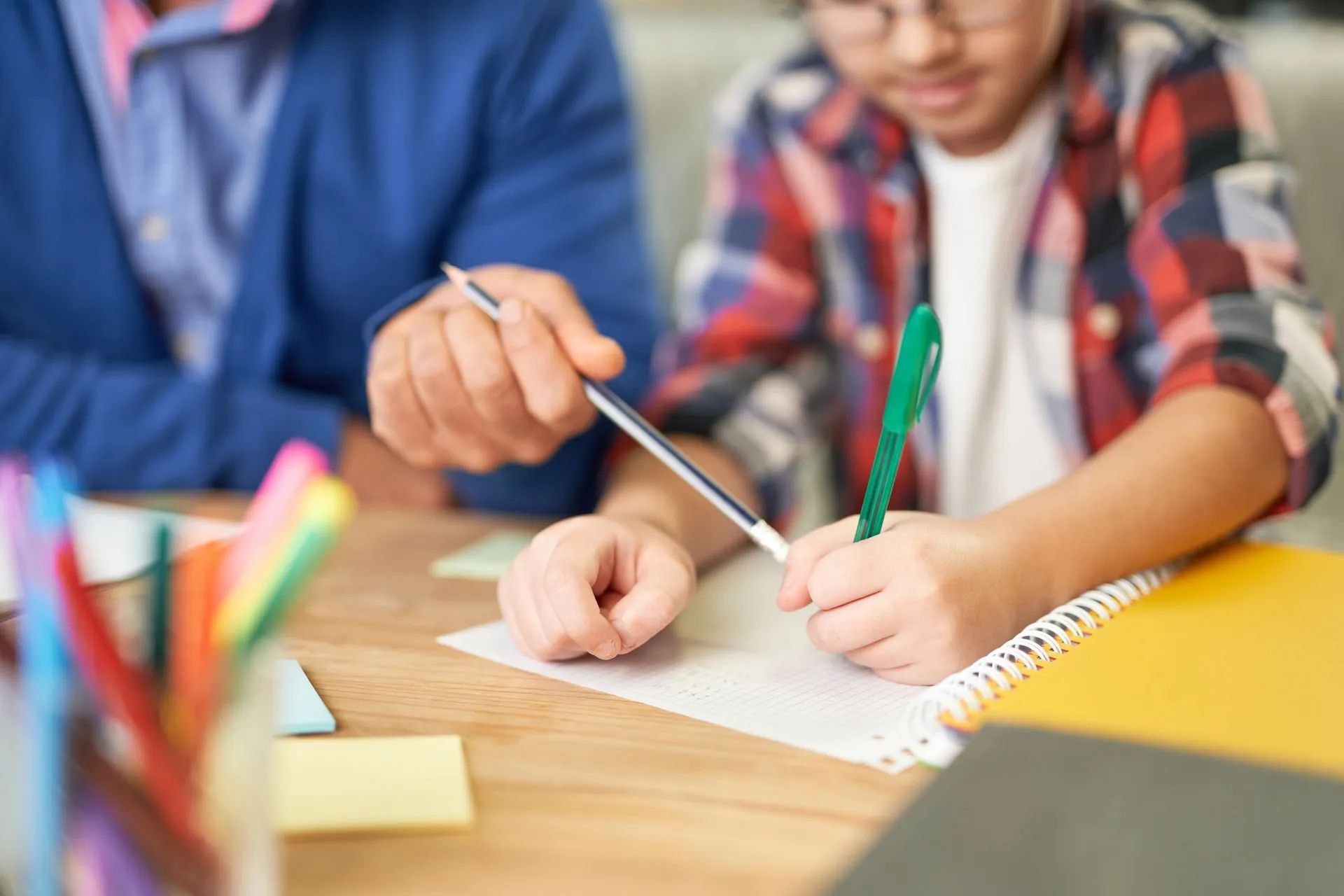 Professeur à domicile pointant la copie d'un élève