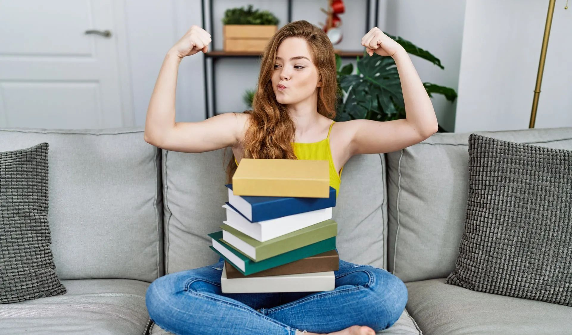 Une pile de livres sur les genoux d'une étudiante