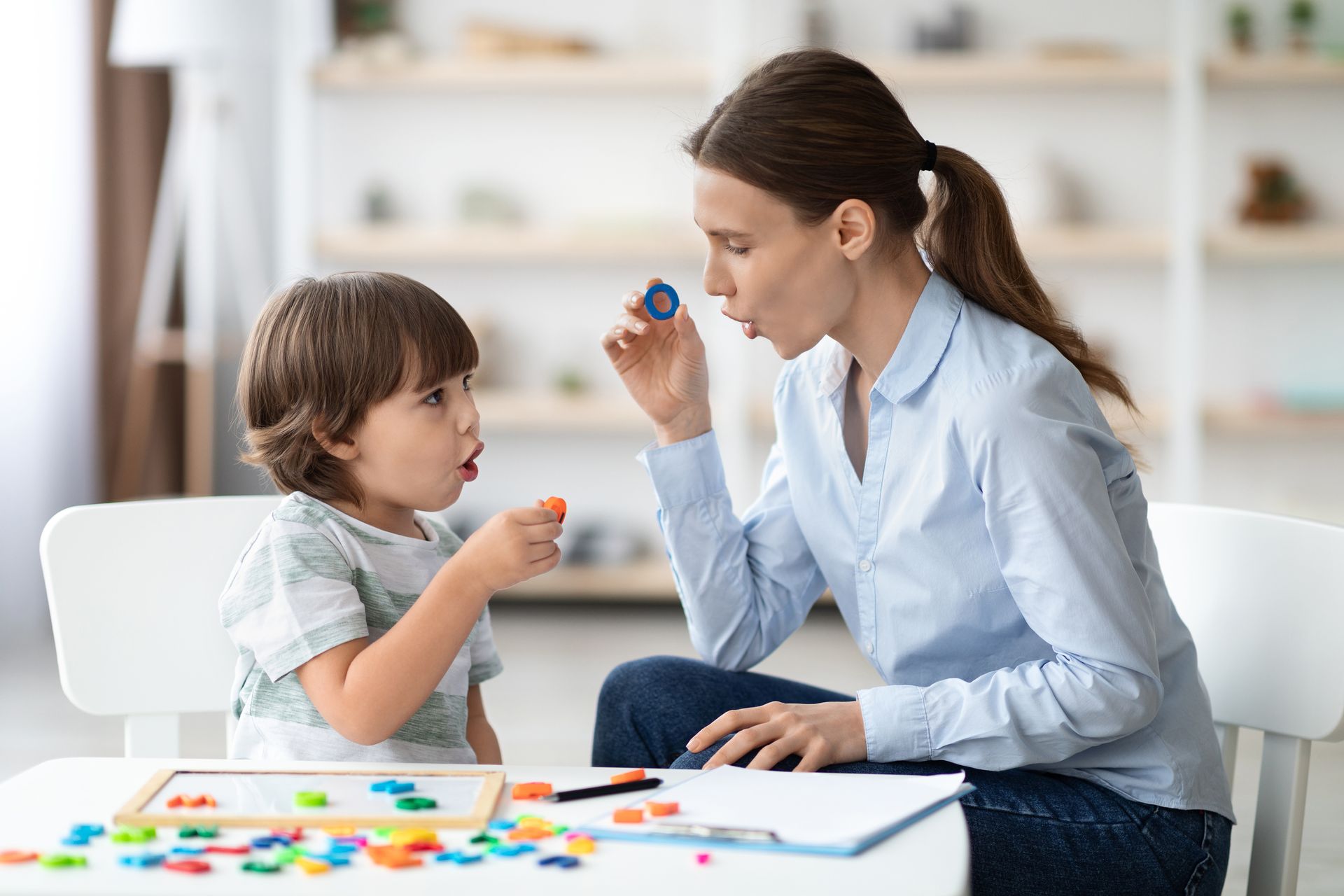Une femme et un enfant jouent avec des lettres colorées
