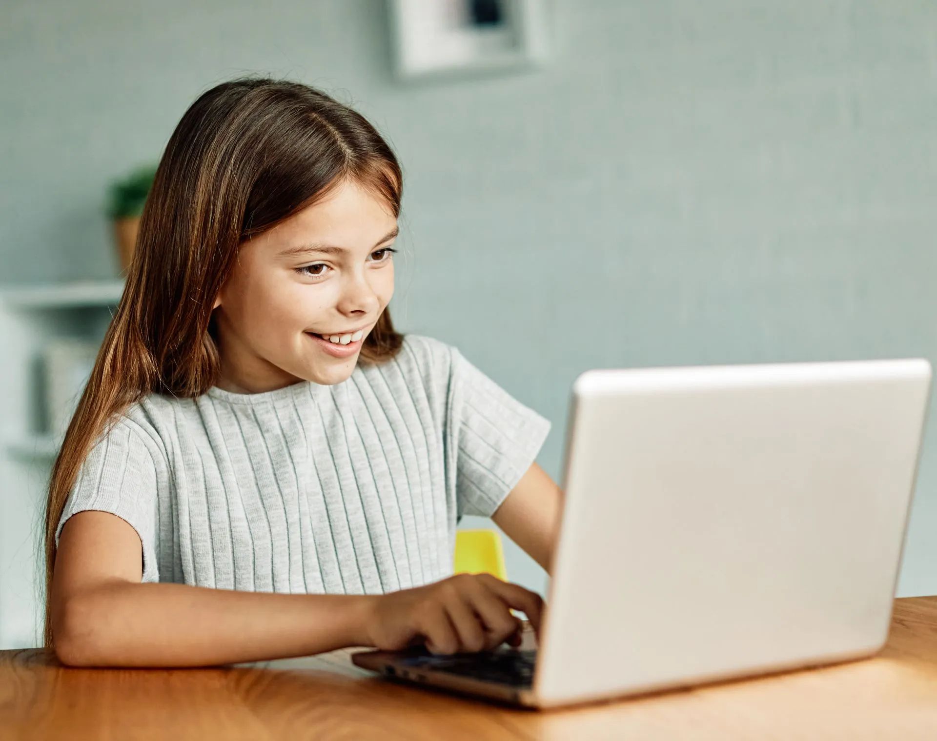 Jeune fille souriante devant l'écran d'un ordinateur portable