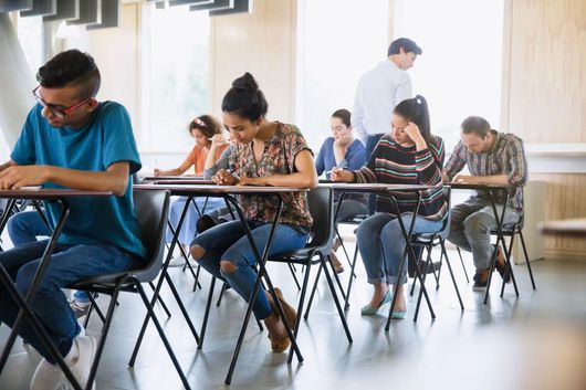 Des étudiants passent un examen dans une salle lumineuse