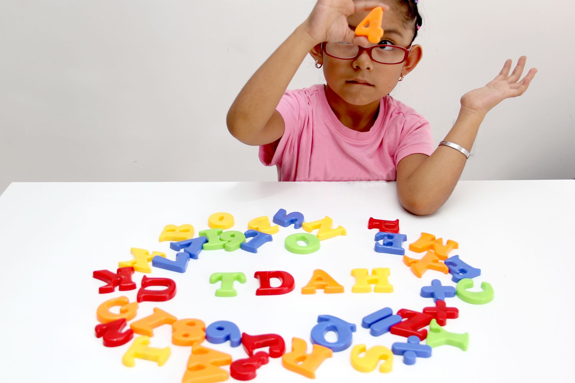 Jeune fille formant le mot TDAH avec des lettres de couleurs