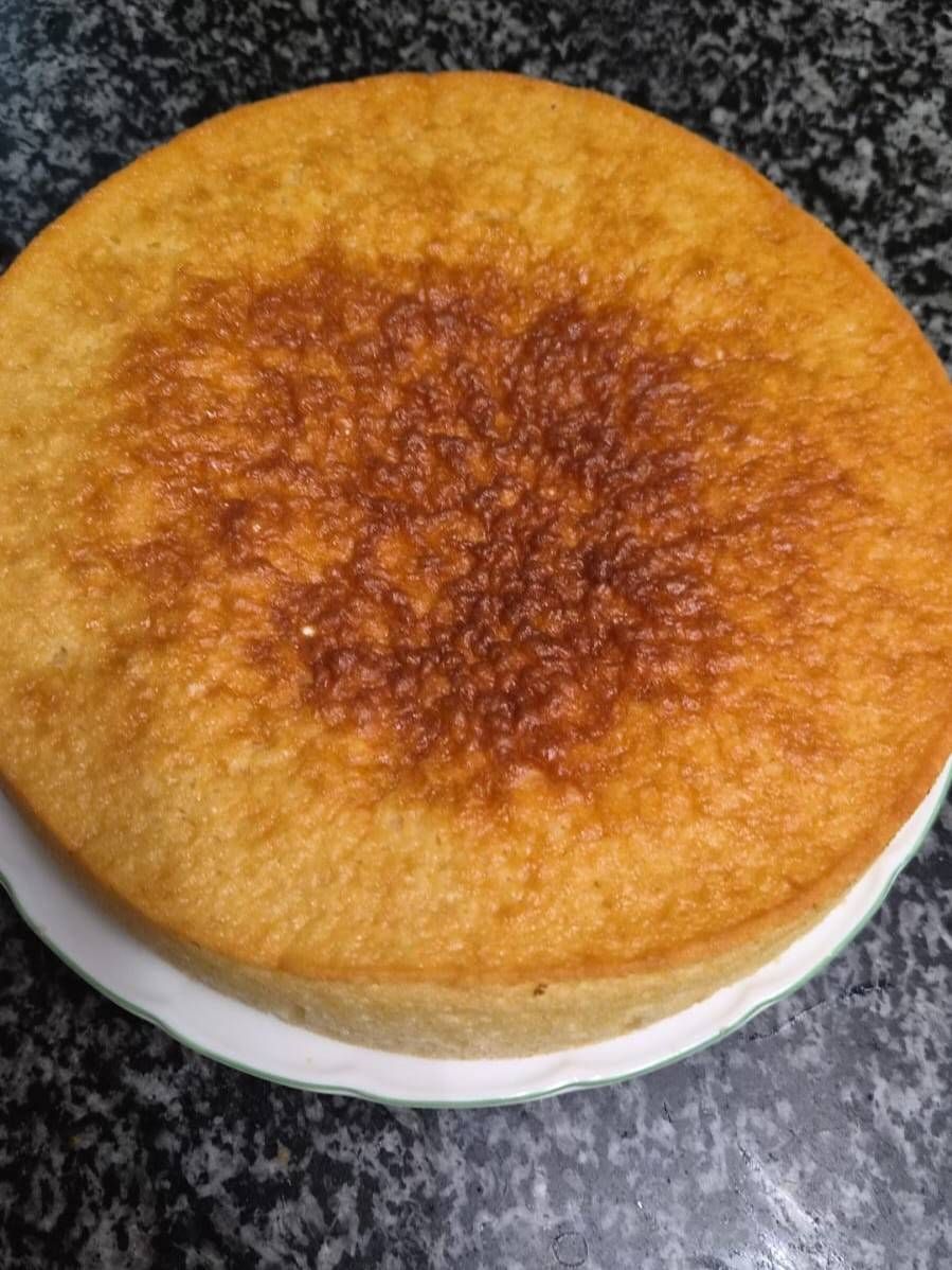 Pastel redondo de color marrón dorado sobre un plato, con el centro de un tono marrón más oscuro.