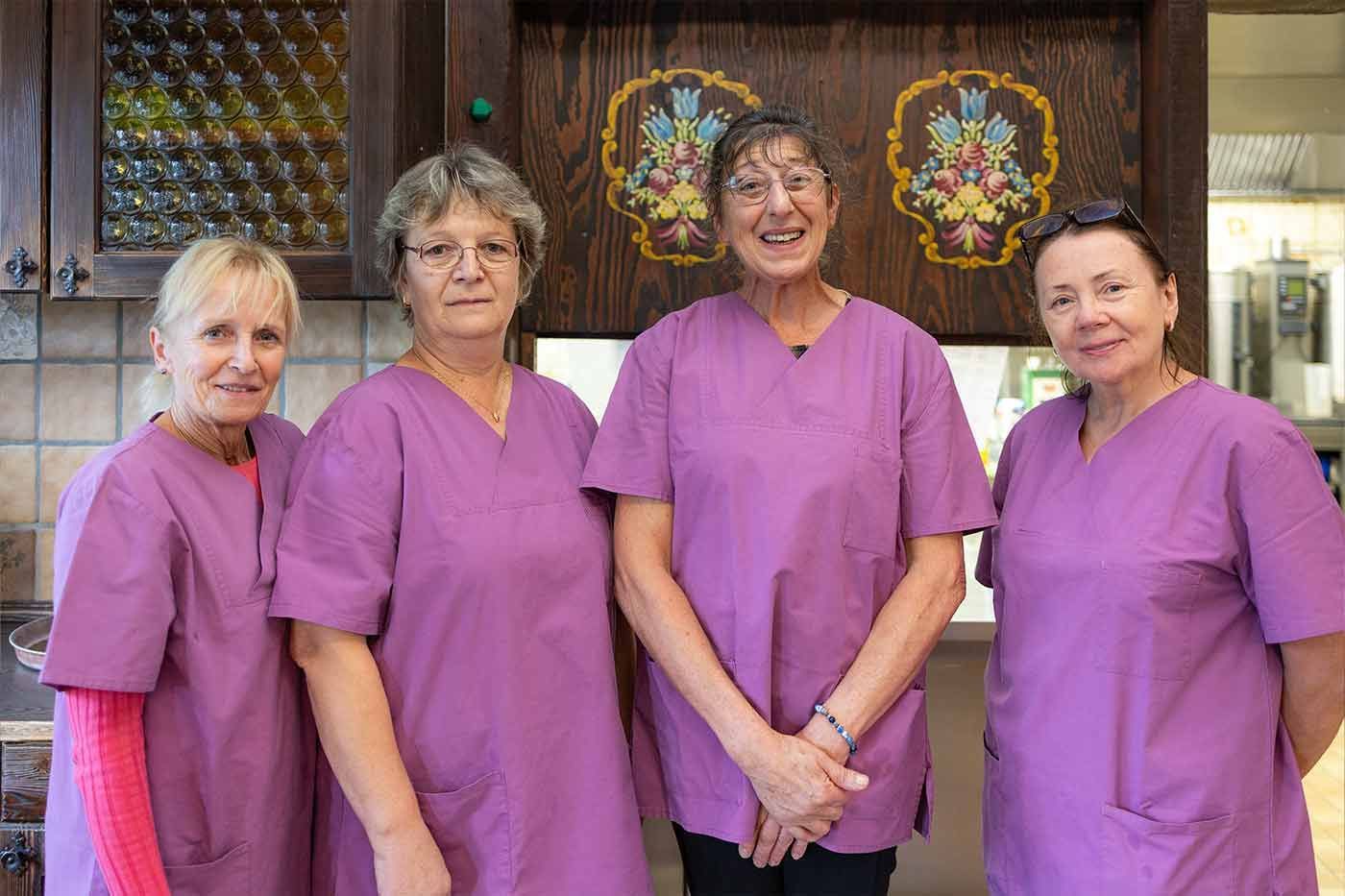 Eine Gruppe von Frauen in lila OP-Kleidung posiert für ein Foto.