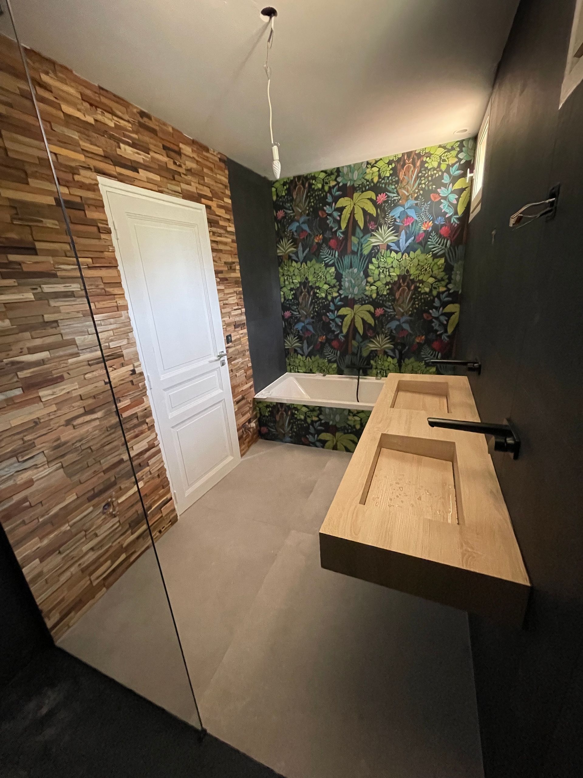Rénovation de douche avec lavabo en bois et peinture murale derrière la baignoire