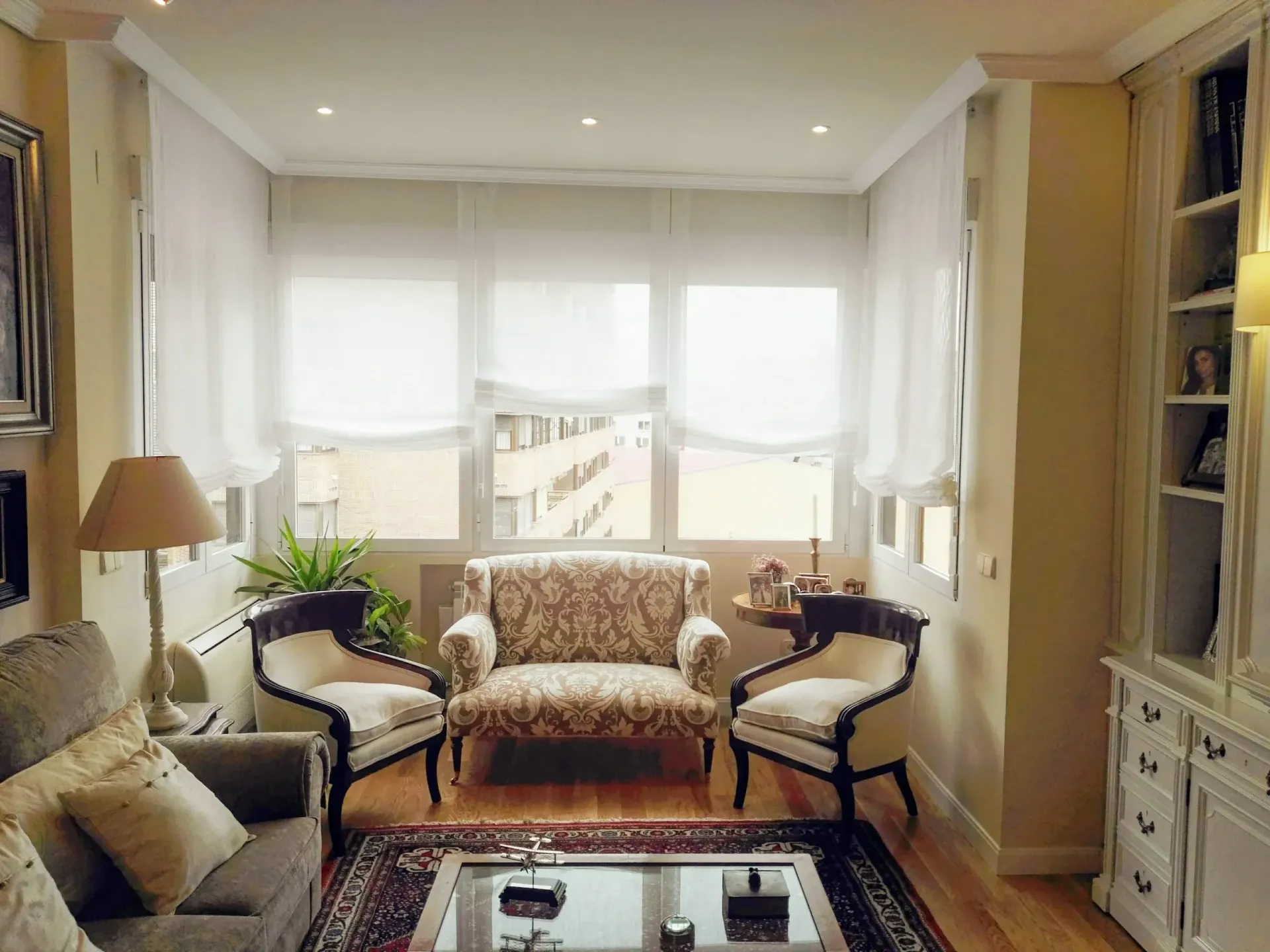 Una sala de estar con un sofá, sillas y una mesa de café.