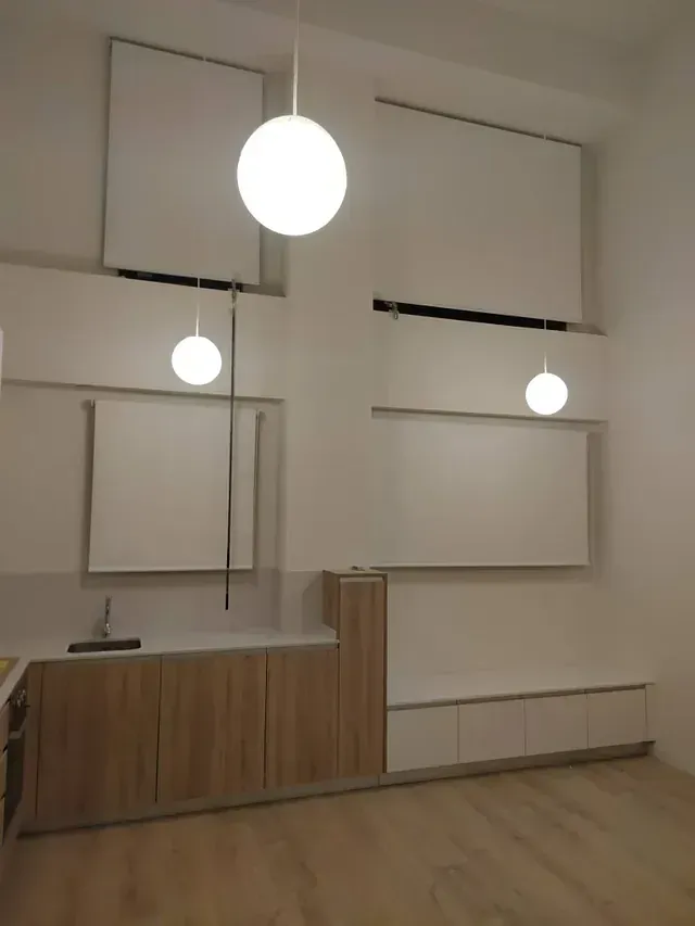 Una cocina con gabinetes de madera y paredes blancas.