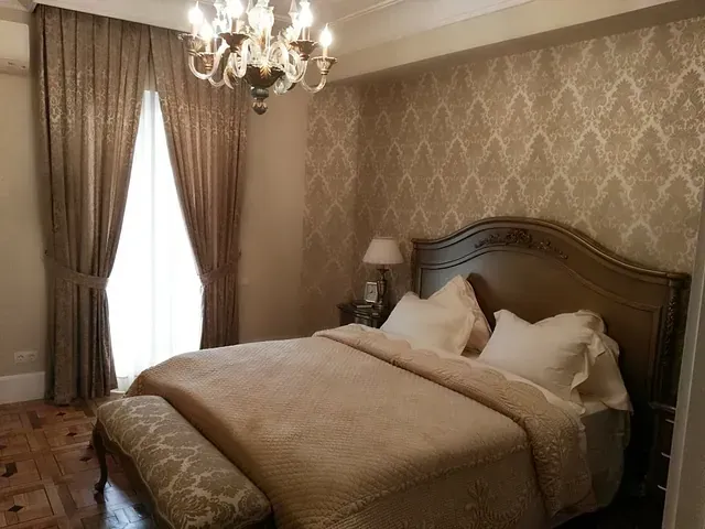 Un dormitorio con una cama grande y una lámpara de araña.