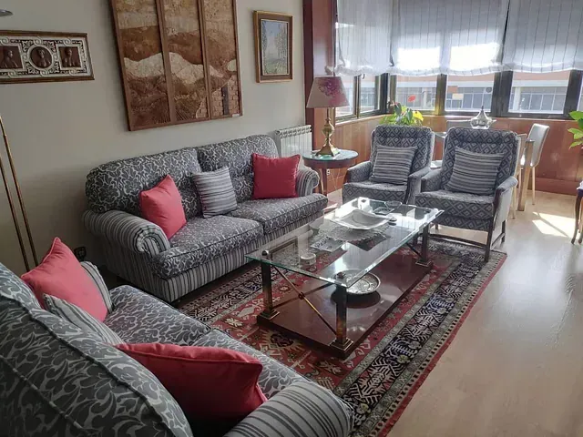 Una sala de estar con un sofá, sillas y una mesa de café.