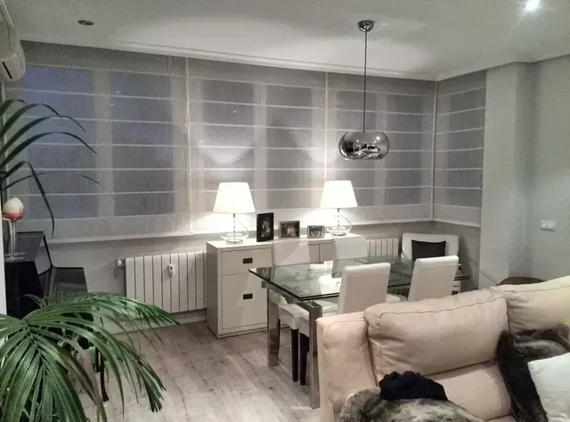 Una sala de estar con un sofá, una mesa y sillas.