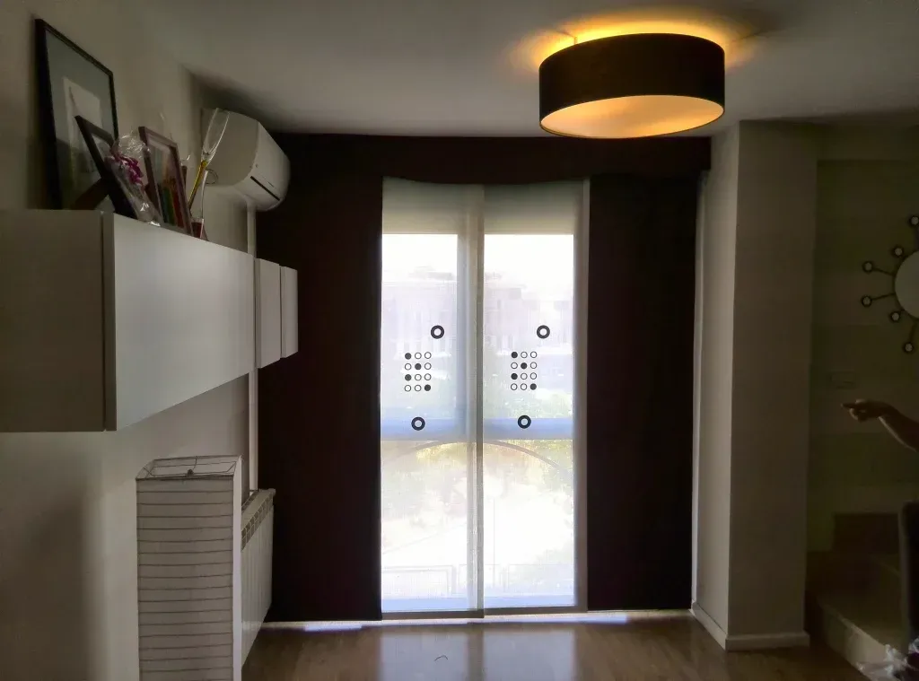 Una sala de estar con puertas corredizas de vidrio y una luz de techo.