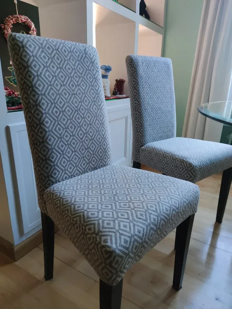 Dos sillas de comedor están una al lado de la otra en una sala de estar.