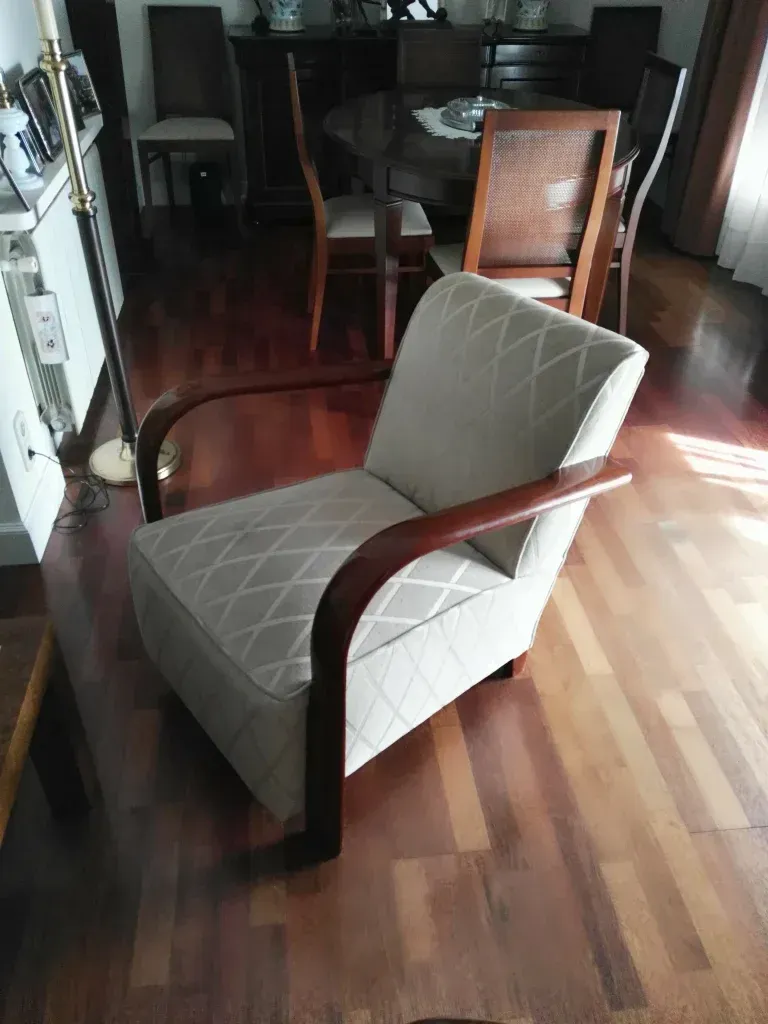 Una silla está colocada sobre un piso de madera en una sala de estar.