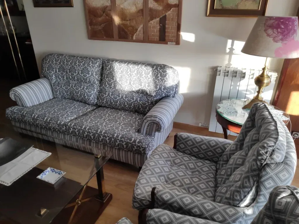 Una sala de estar con un sofá y dos sillas