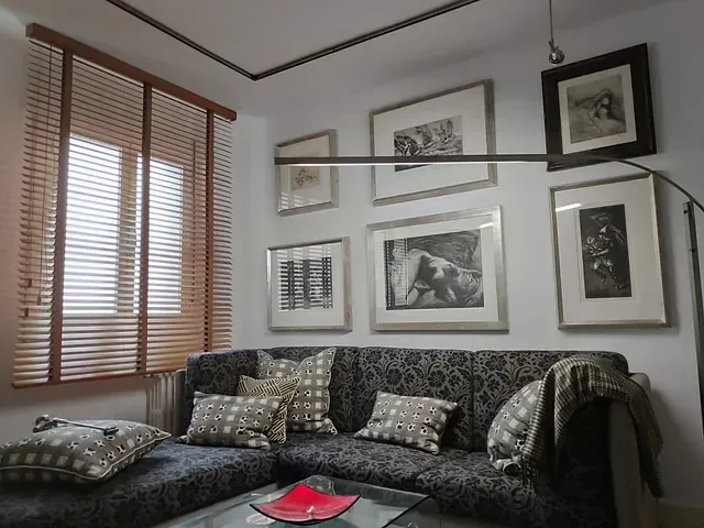 Una sala de estar con un sofá y cuadros en la pared.