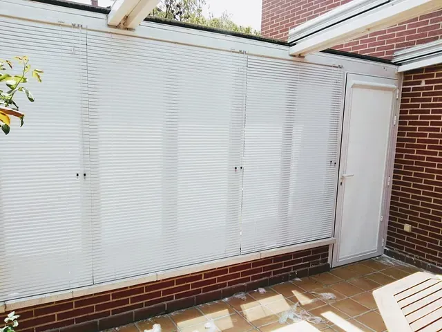 Una pared de ladrillos con gabinetes blancos y una puerta blanca.