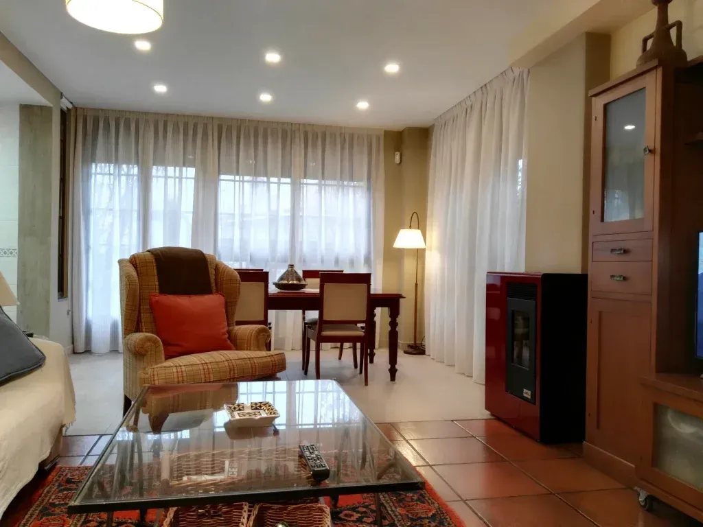 Una sala de estar con una mesa de centro de cristal y sillas.