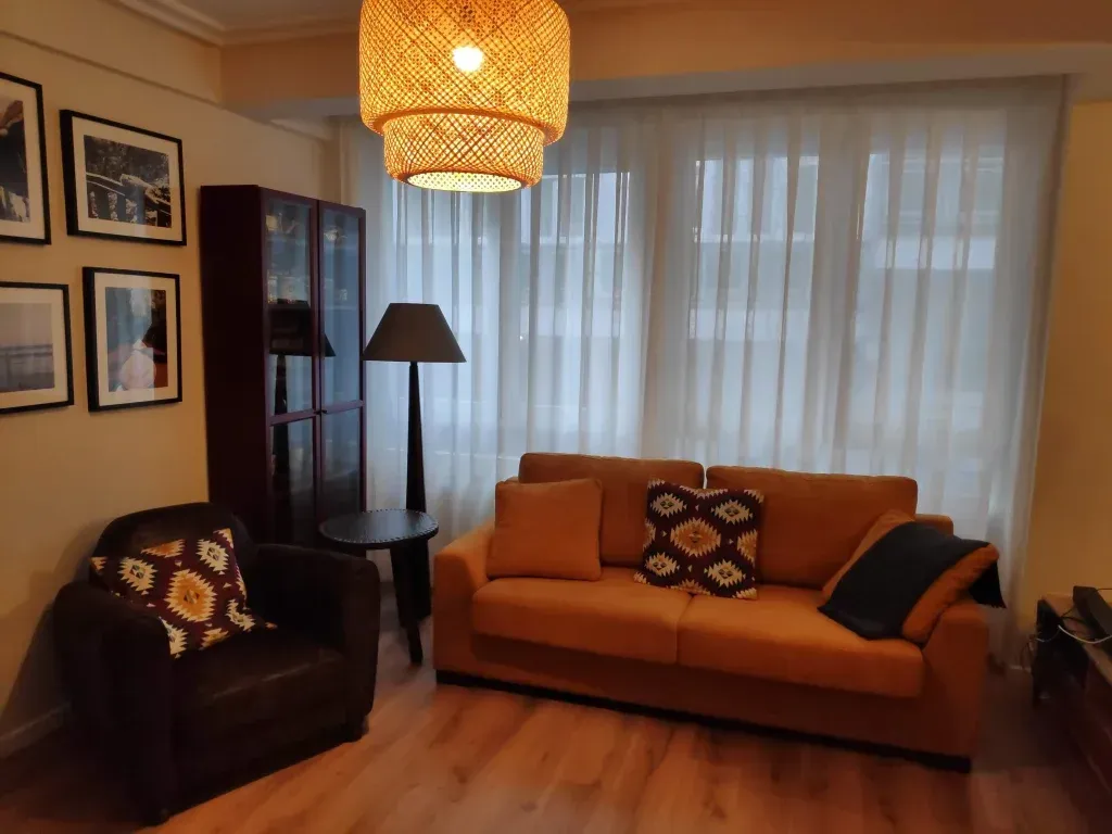 Una sala de estar con un sofá, una silla y una lámpara.