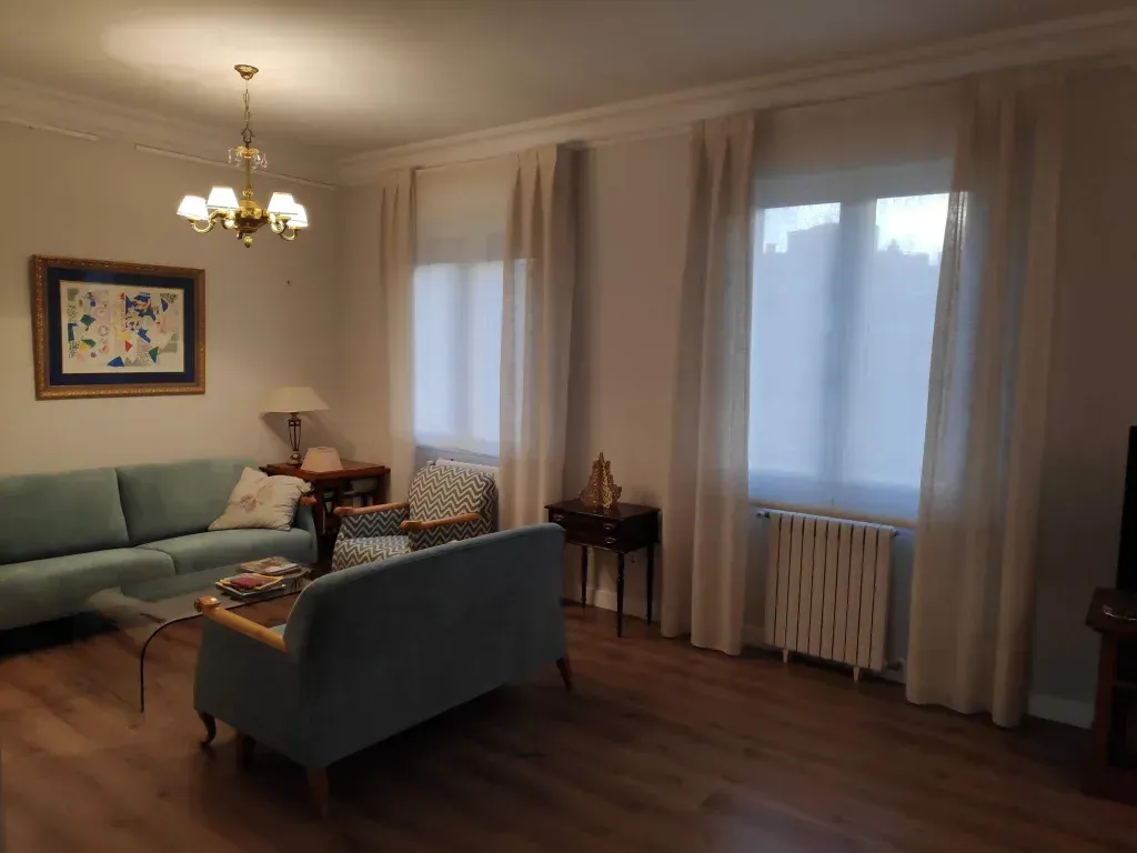 Una sala de estar con un sofá, sillas y una lámpara de araña.