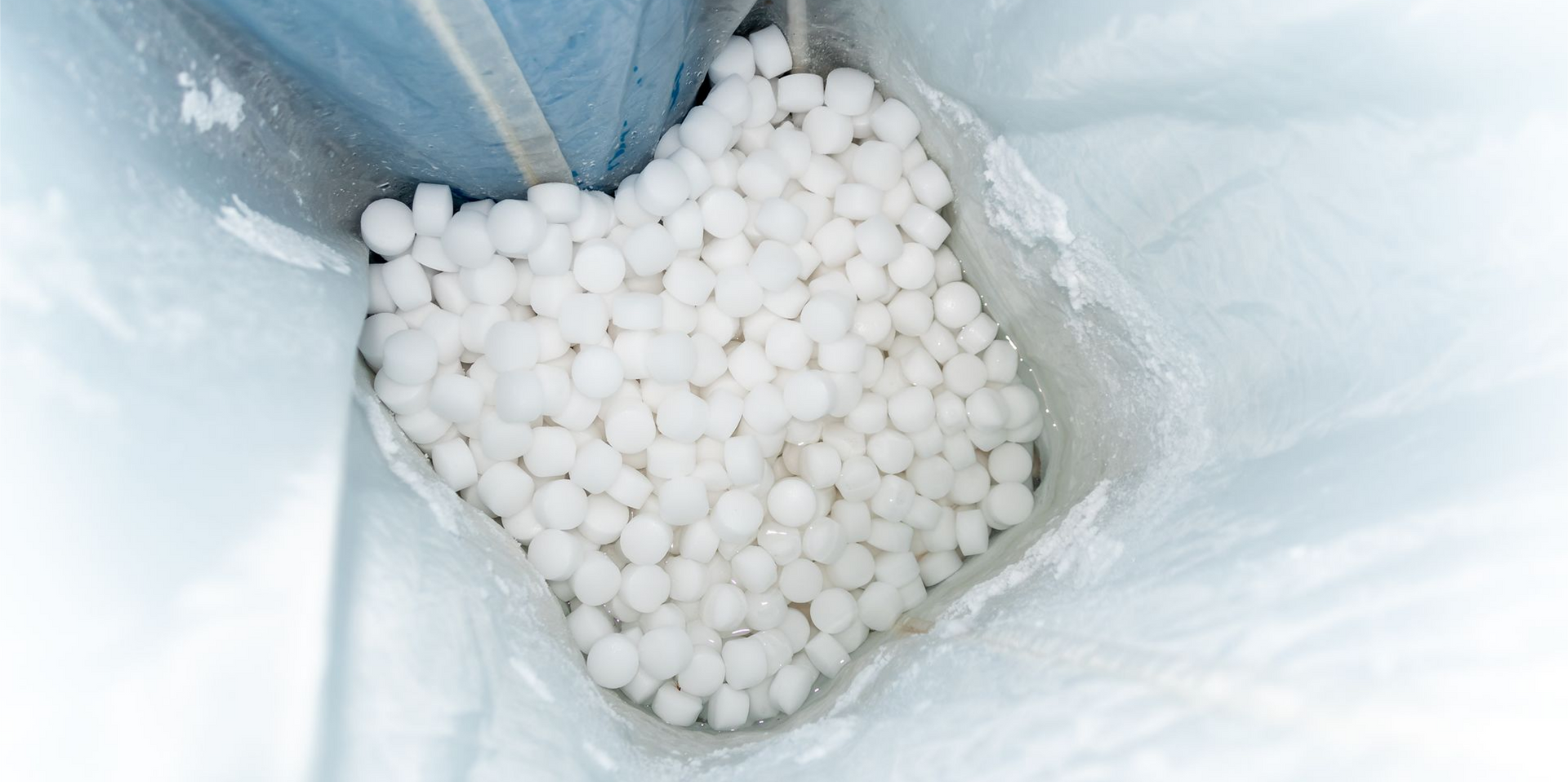 Des granulés blancs à l'intérieur d'un adoucisseur d'eau.
