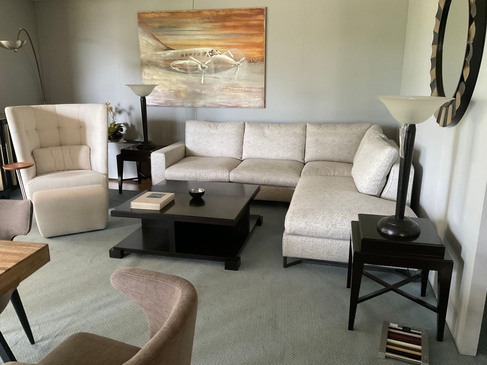 Eingerichtetes Wohnzimmer mit Ecksofa, Sessel, Lampe, Tisch und Dekorationen