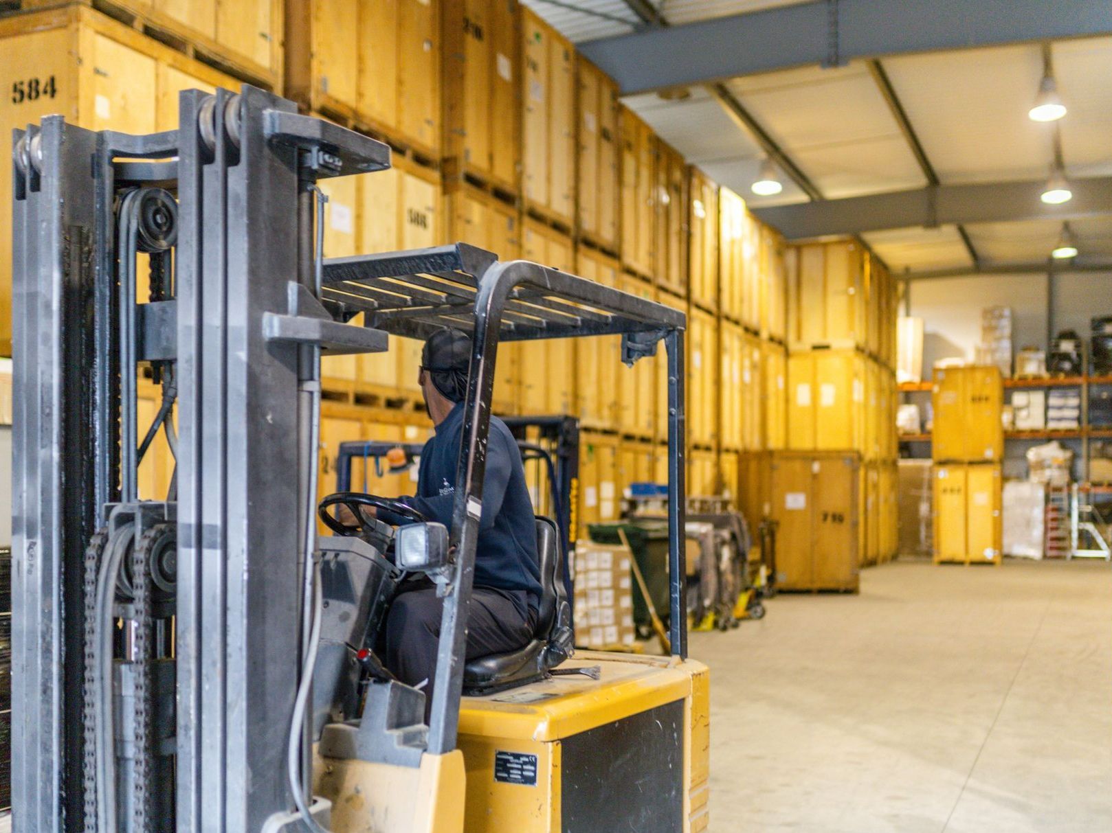 Un employé avec un monte-charge dans le garde meuble