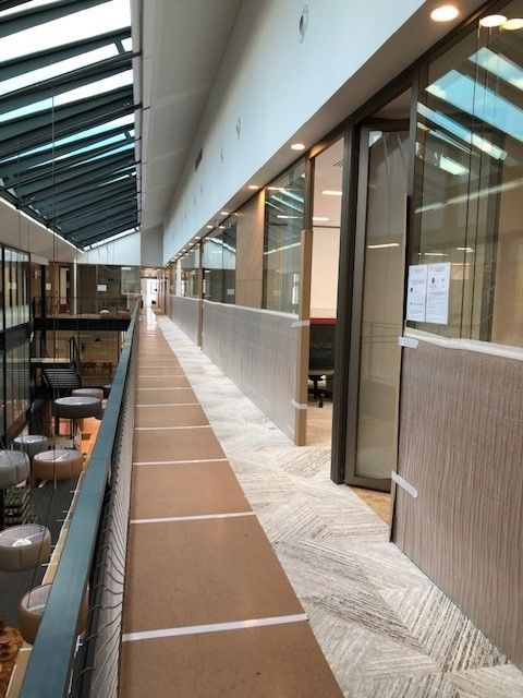 Couloir de bureaux avec des murs et le sol protégés par des cartons scotchés