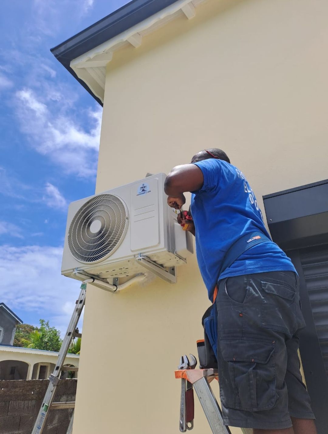 Un homme intervenant sur le groupe extérieur d'une climatisation