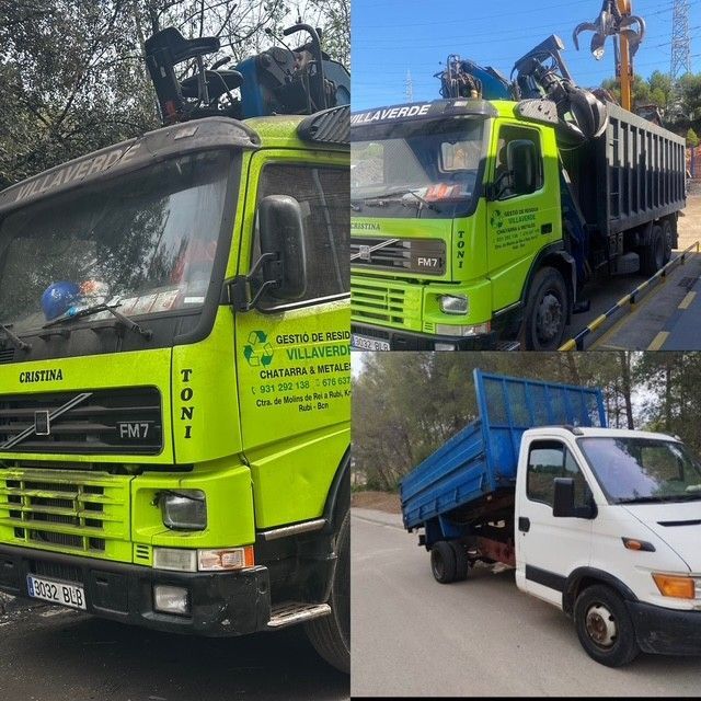 Un camión verde con una grúa encima está estacionado frente a un edificio.