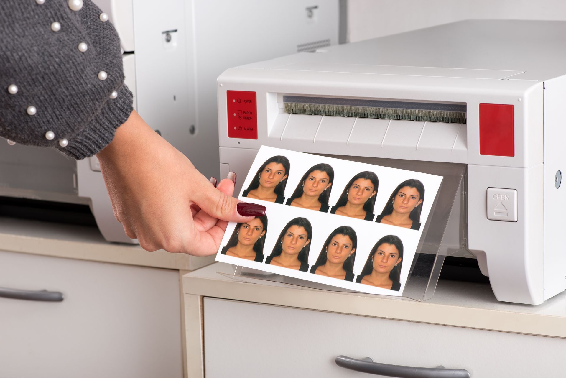 Photos de visages imprimées sortant d'une imprimante de bureau.