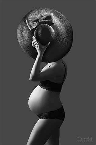 Illustration en niveaux de gris d'une femme enceinte portant un grand chapeau, posant de profil sur un fond uni.