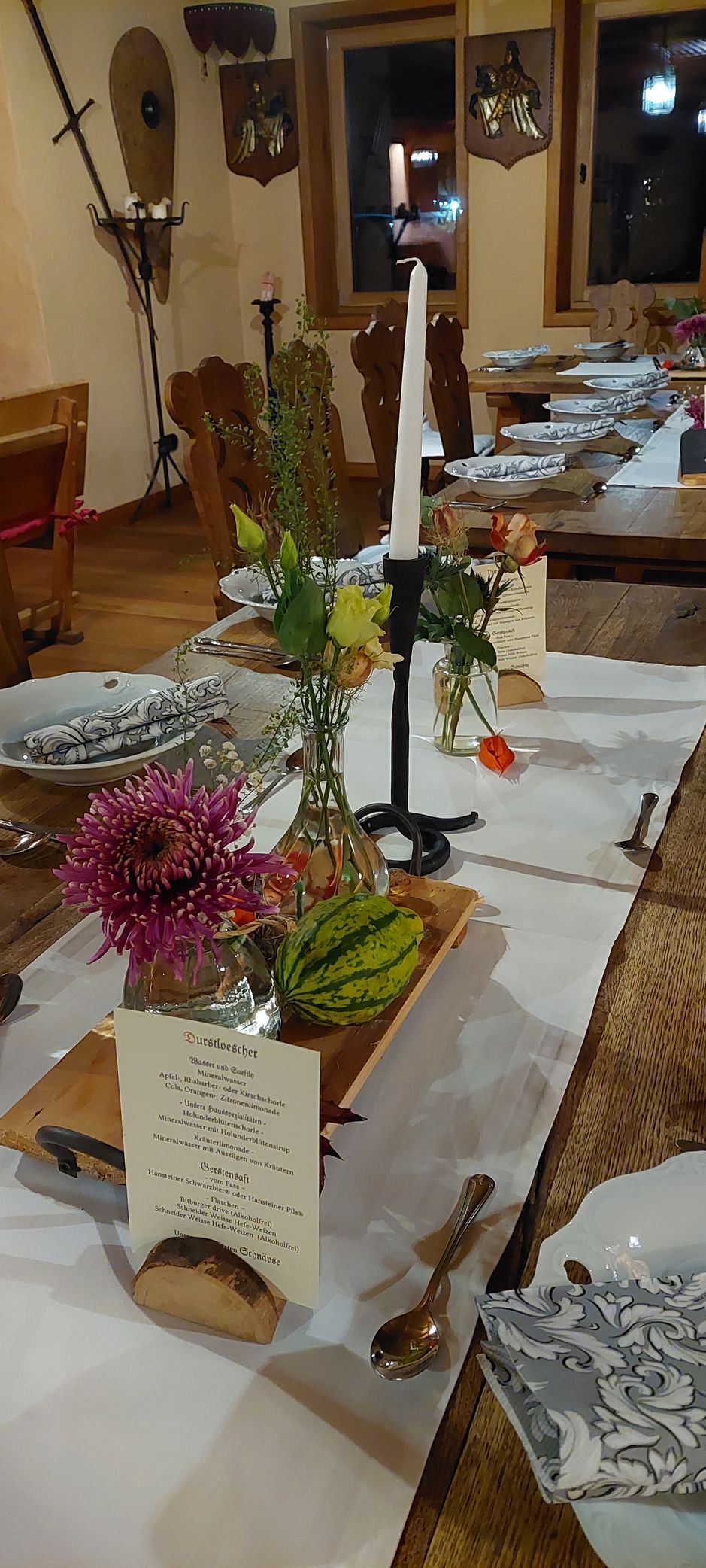 Elegante Tischfloristik mit violetten Blüten und Kerzenständer für Hochzeit