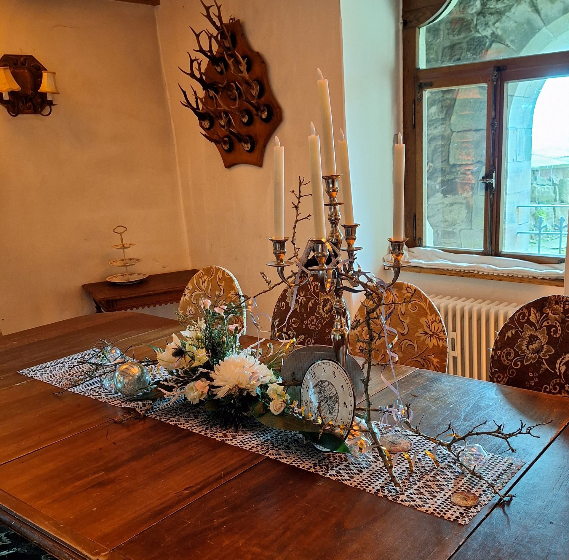 Rustikale Eventdekoration mit Kerzen und floralen Akzenten im historischen Ambiente