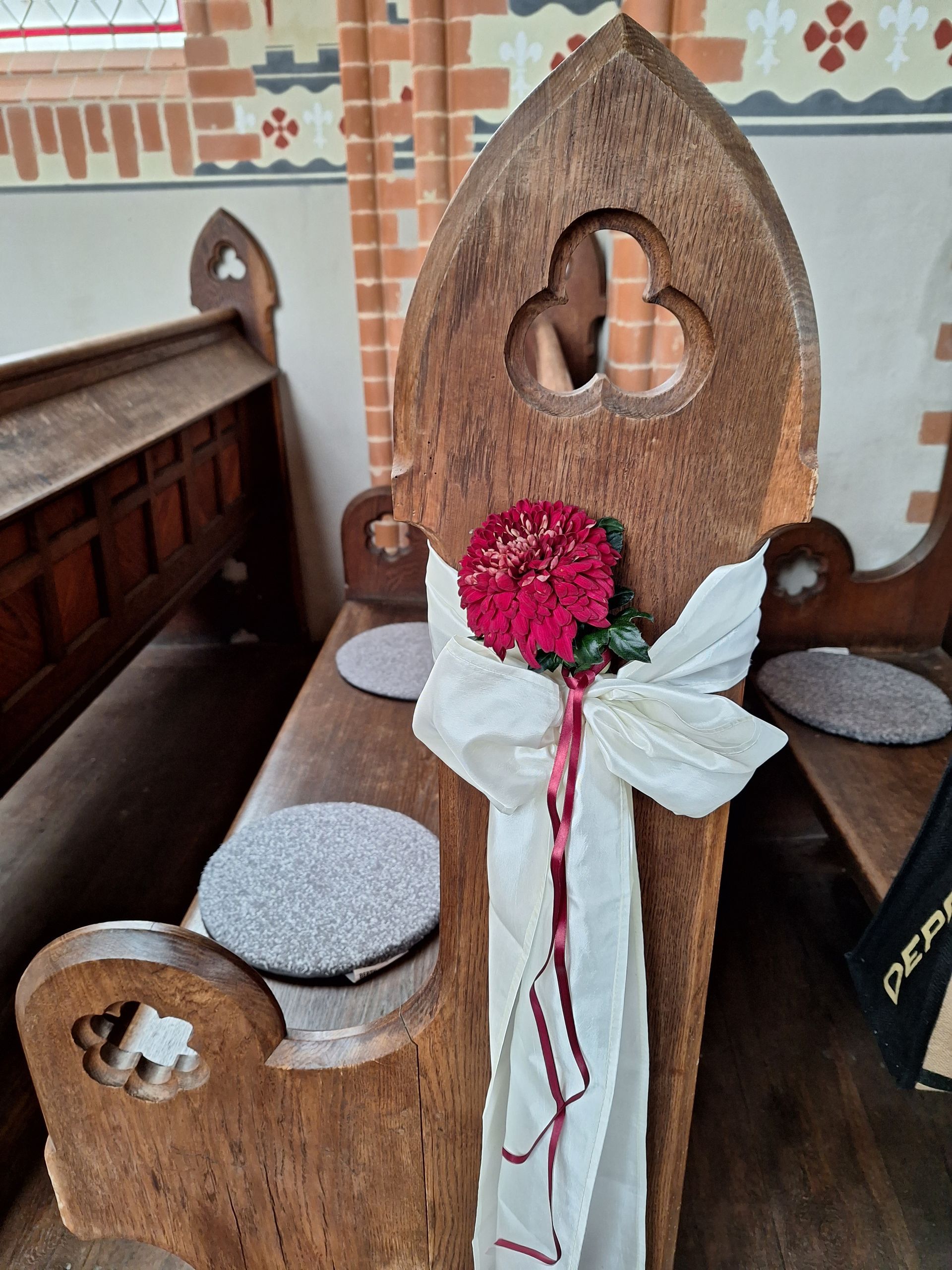 Kirchendekoration mit Blumenherz und Schleifen für Hochzeit oder Taufe
