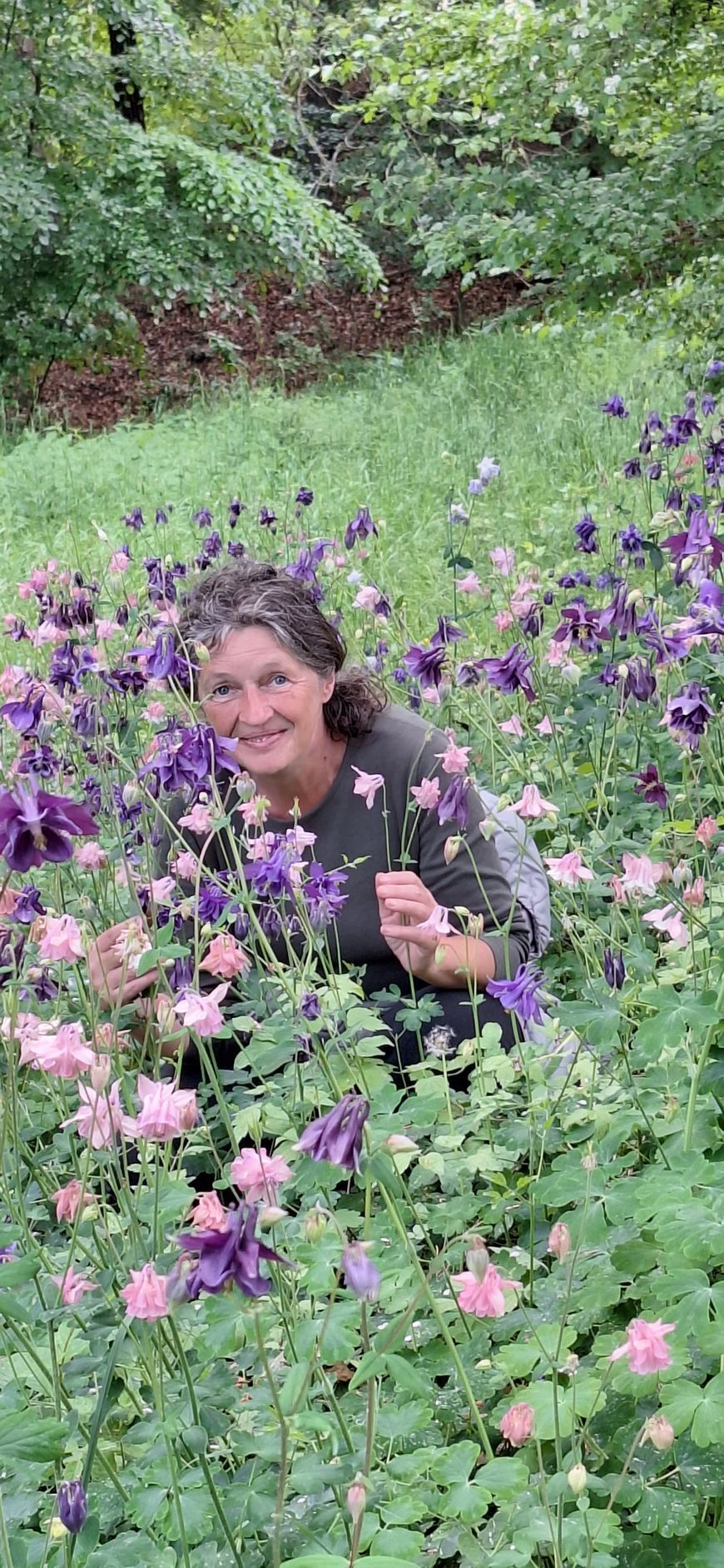 Floristin und Inhaberin Marion Hartleib im Blumenfeld mit violetten Blüten und natürlicher Floristik