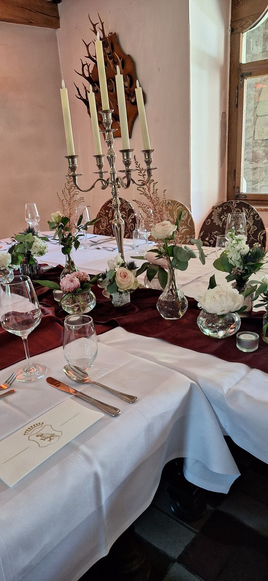 Festliche Tischdekoration mit weißen Blumen und eleganter Glasfloristik