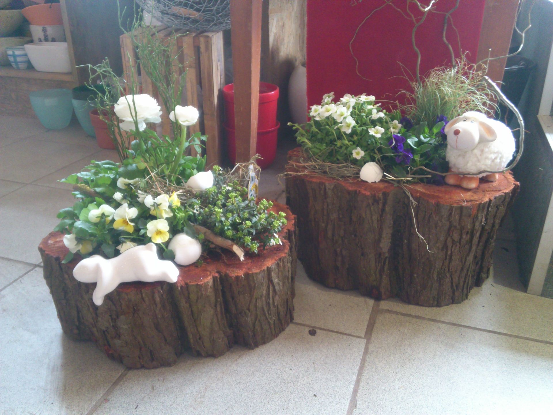 Frühlingsdekoration mit Blumen auf Holzstämmen und natürlicher Osterfloristik