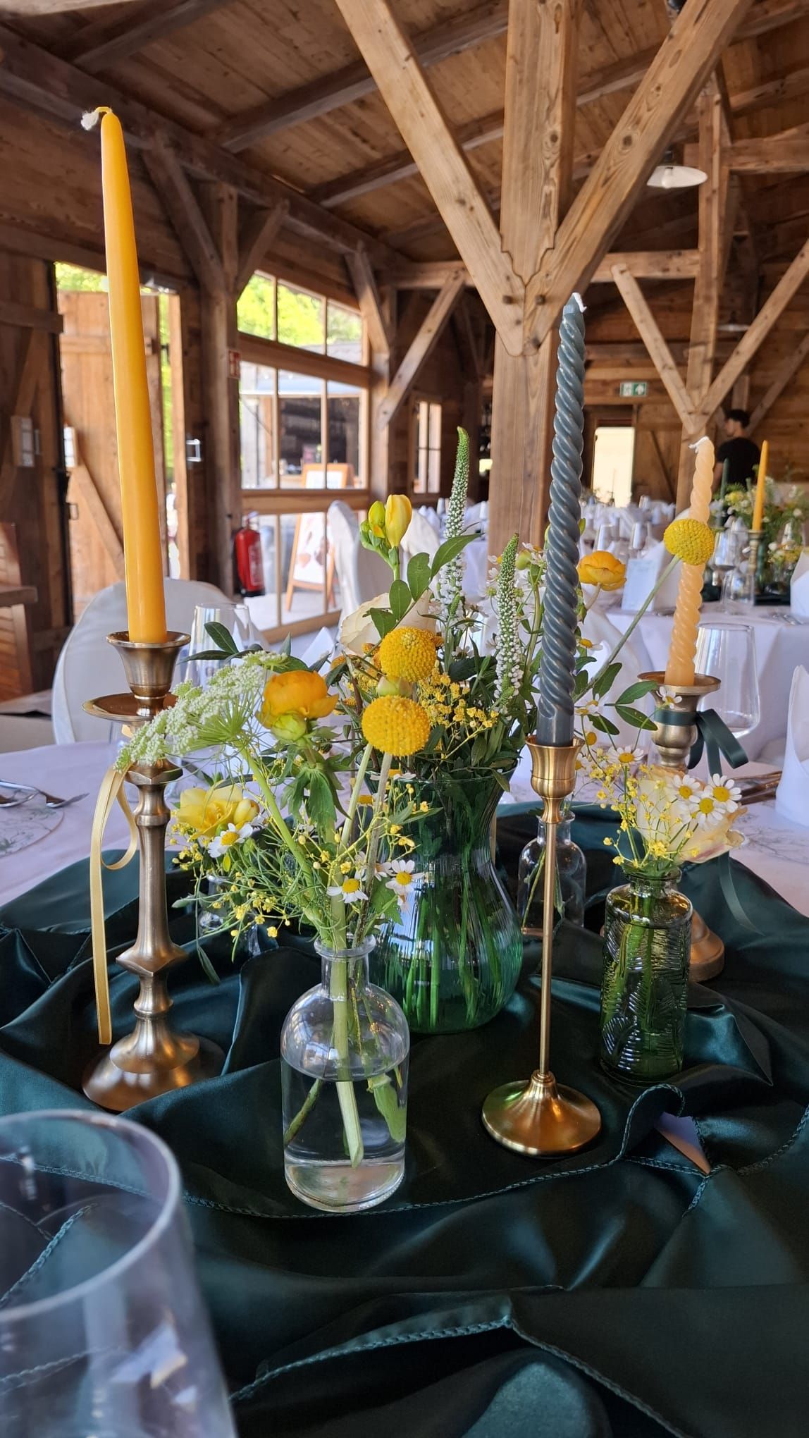 Tischdekoration mit gelben Blumen und Kerzen für festliche Anlässe