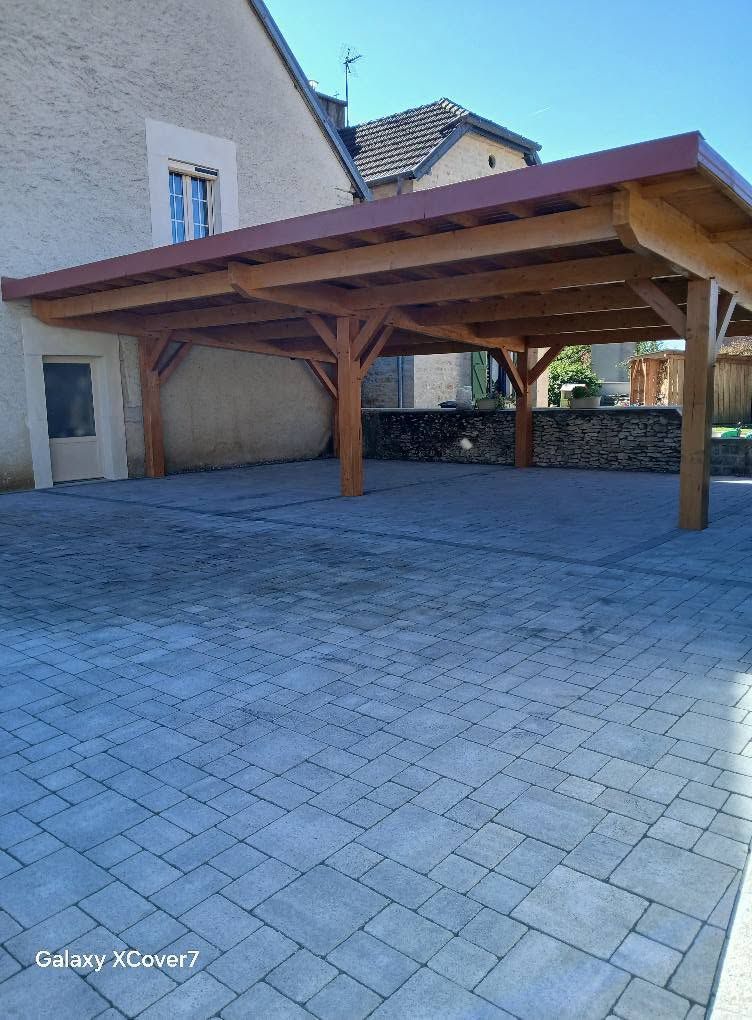 Réalisation d’un carport en bois et pose de pavés pour l’aménagement d’une cour extérieure. Travaux réalisés par la SARL AMZAL, entreprise de maçonnerie intervenant à Gray, Vesoul, Besançon et leurs alentours.