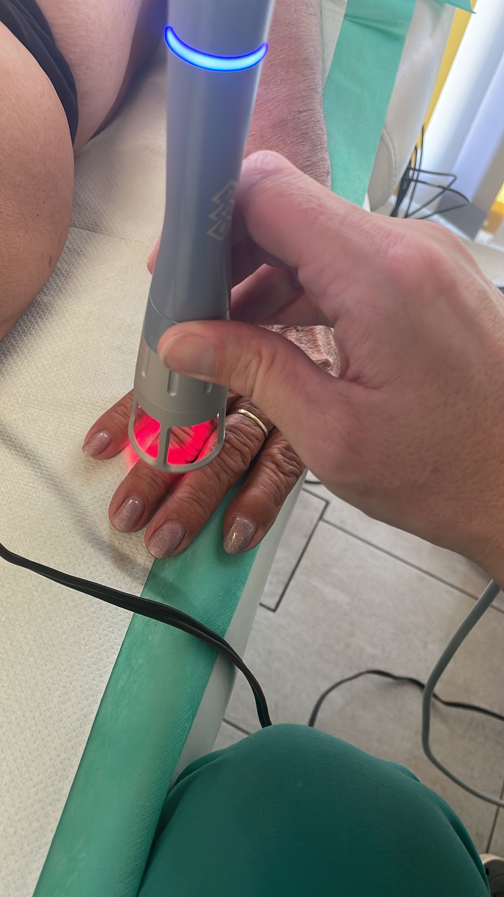 Eine Person benutzt eine Maschine an der Hand einer anderen Person.