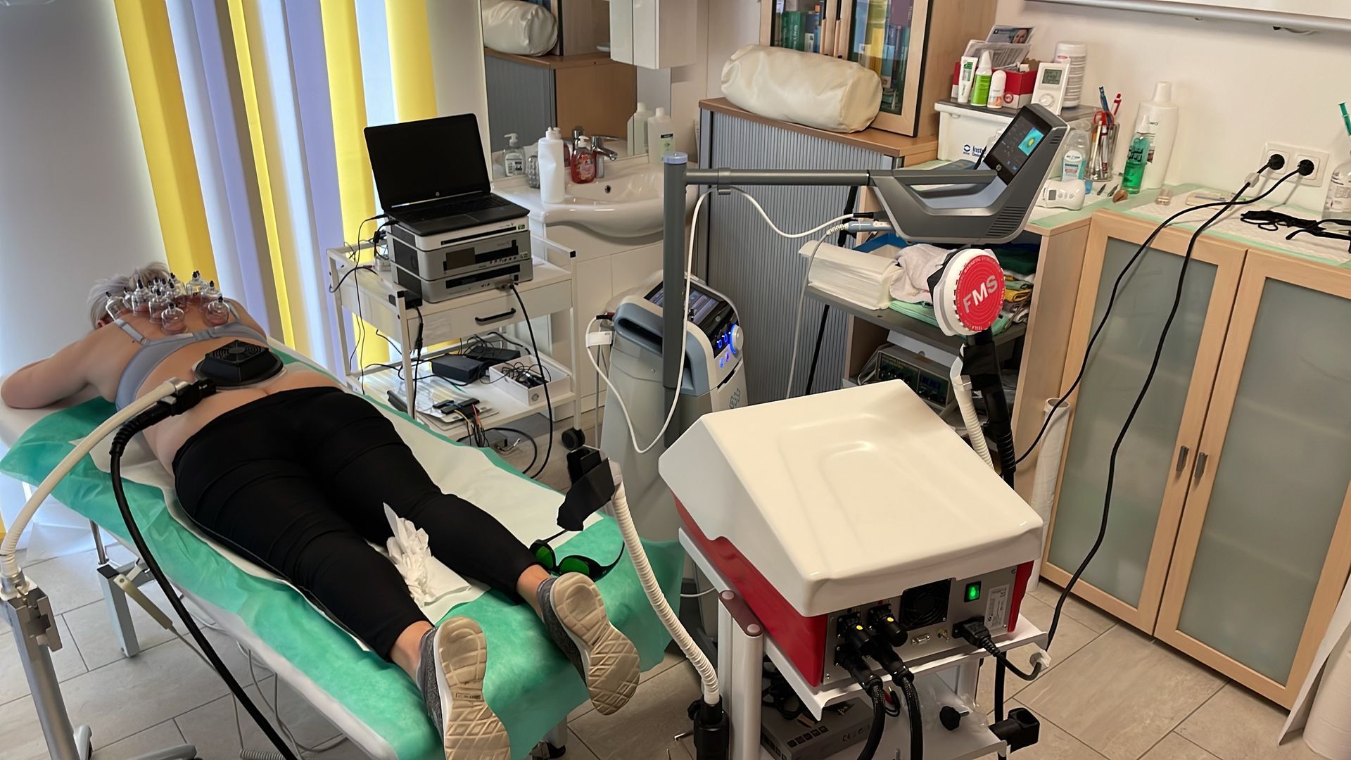Eine Frau liegt auf einem Bett, auf dem eine Maschine steht.