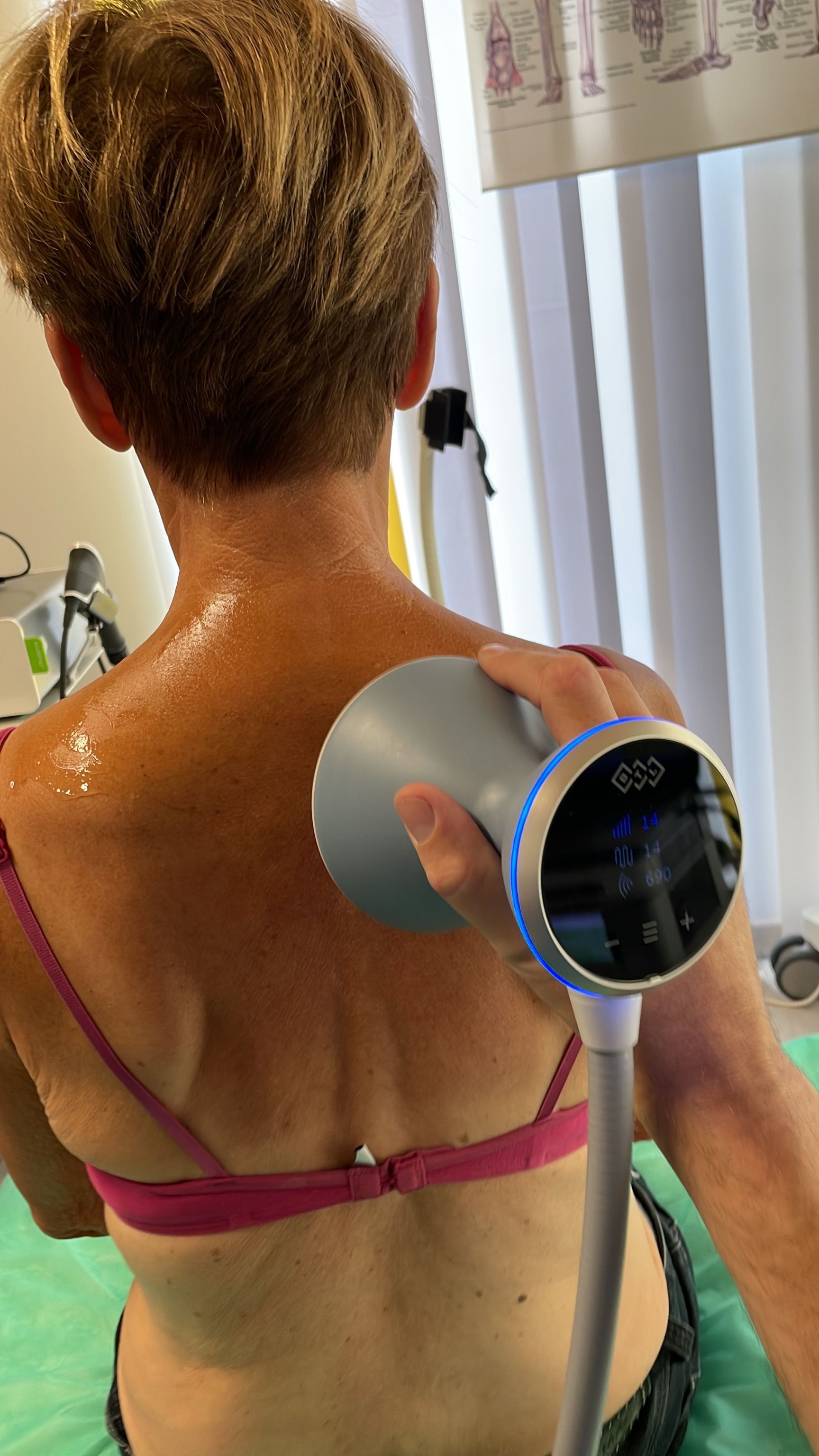 Eine Frau bekommt mit einem Gerät eine Rückenmassage.