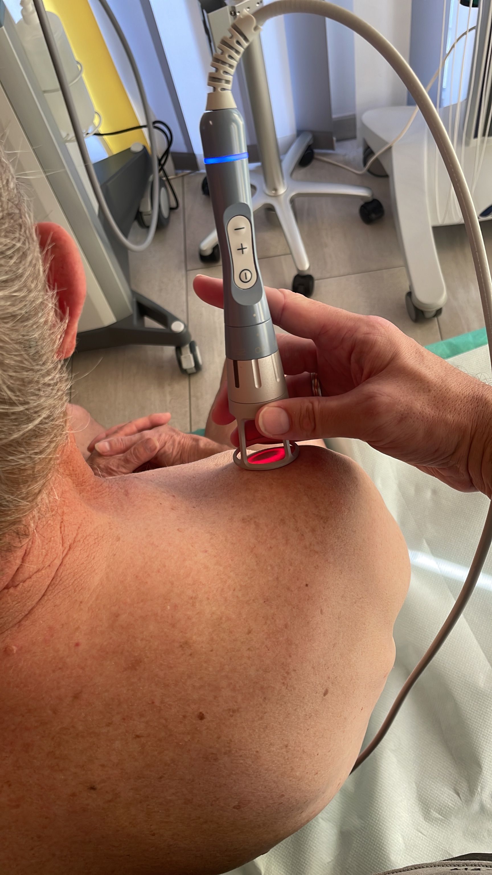 Ein Mann bekommt eine Laserbehandlung an der Schulter.