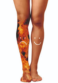 Die Beine einer Frau mit einem Smiley auf dem einen Bein und einem traurigen Gesicht auf dem anderen.