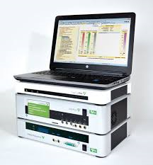 Auf einem Stapel elektronischer Geräte steht ein Laptop.