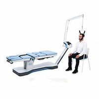 Ein Mann sitzt auf einem Stuhl neben einem Tisch, an dem eine Maschine angeschlossen ist.