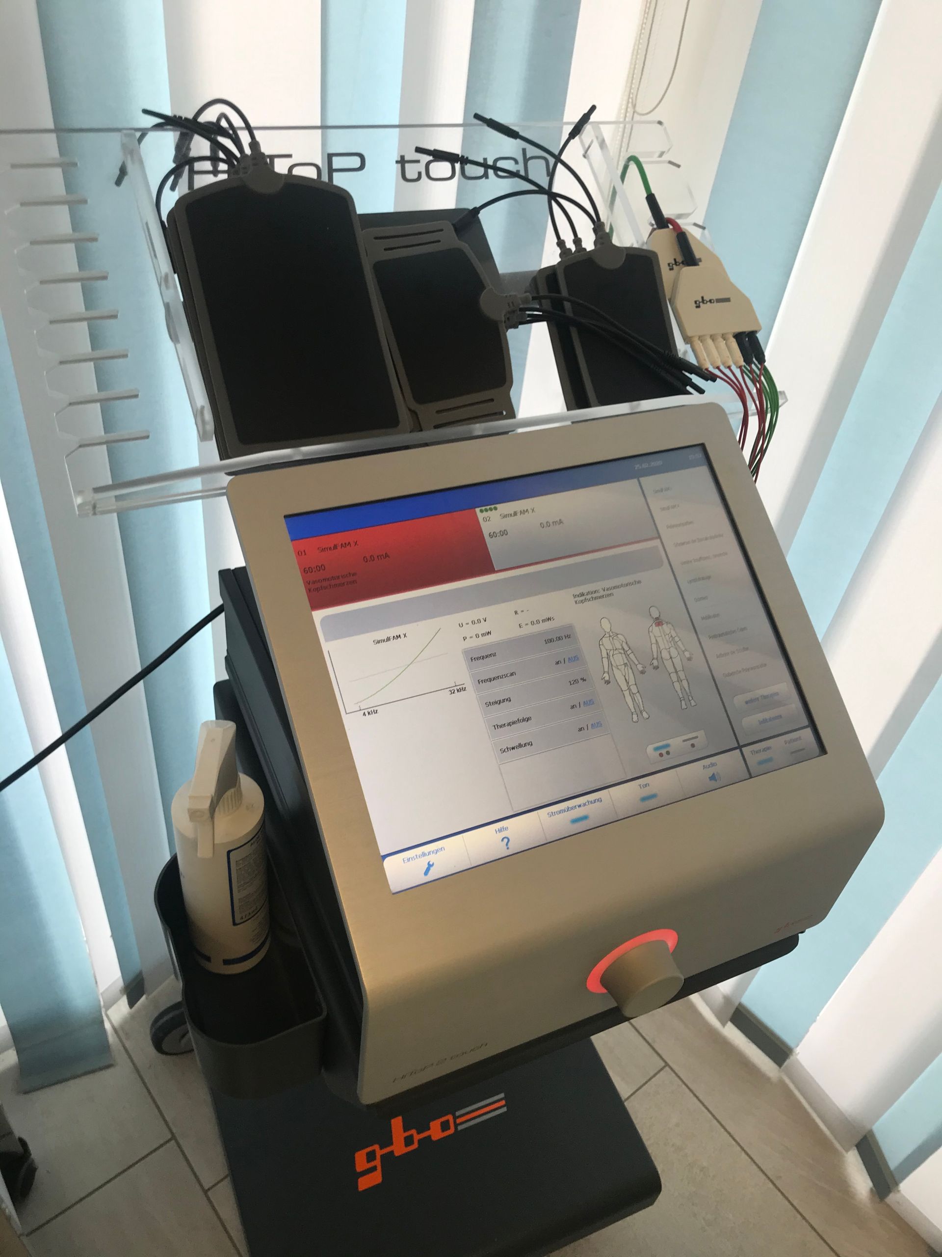 Ein Computermonitor steht auf einem Tisch vor einem Fenster.