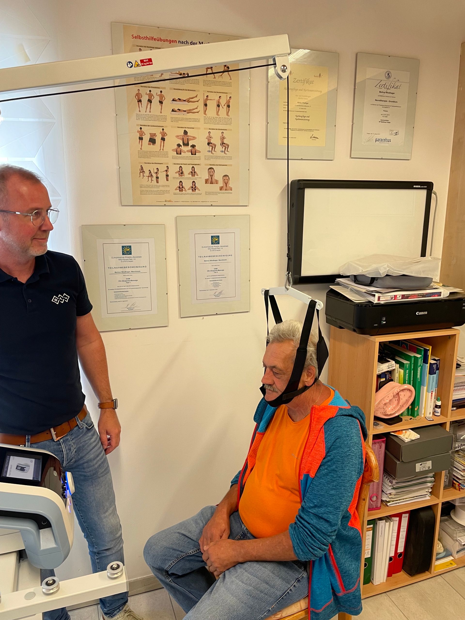 Zwei Männer stehen neben einem Mann, der auf einer Bank sitzt.