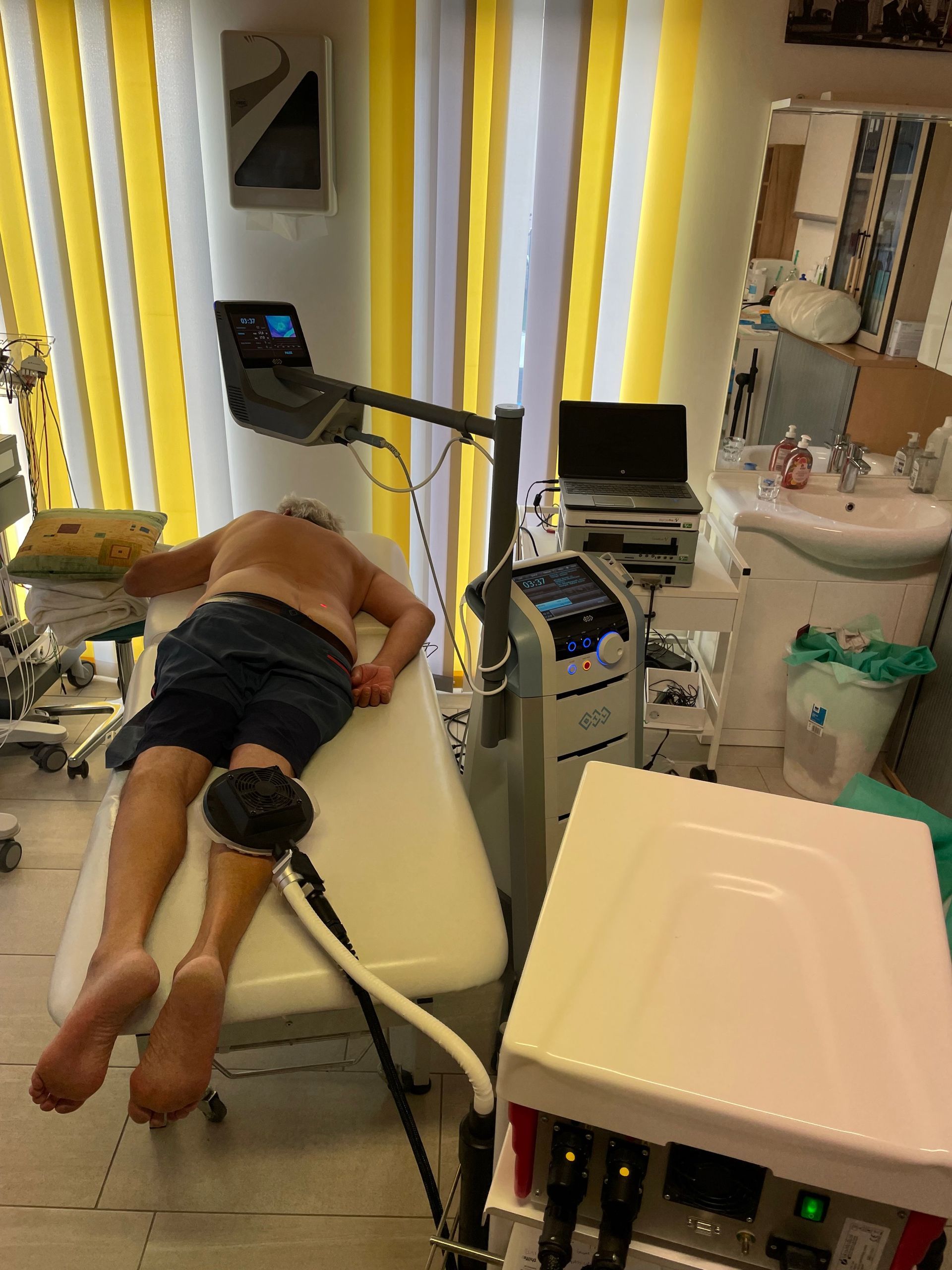 Ein Mann liegt auf einem Bett in einem Krankenhauszimmer.